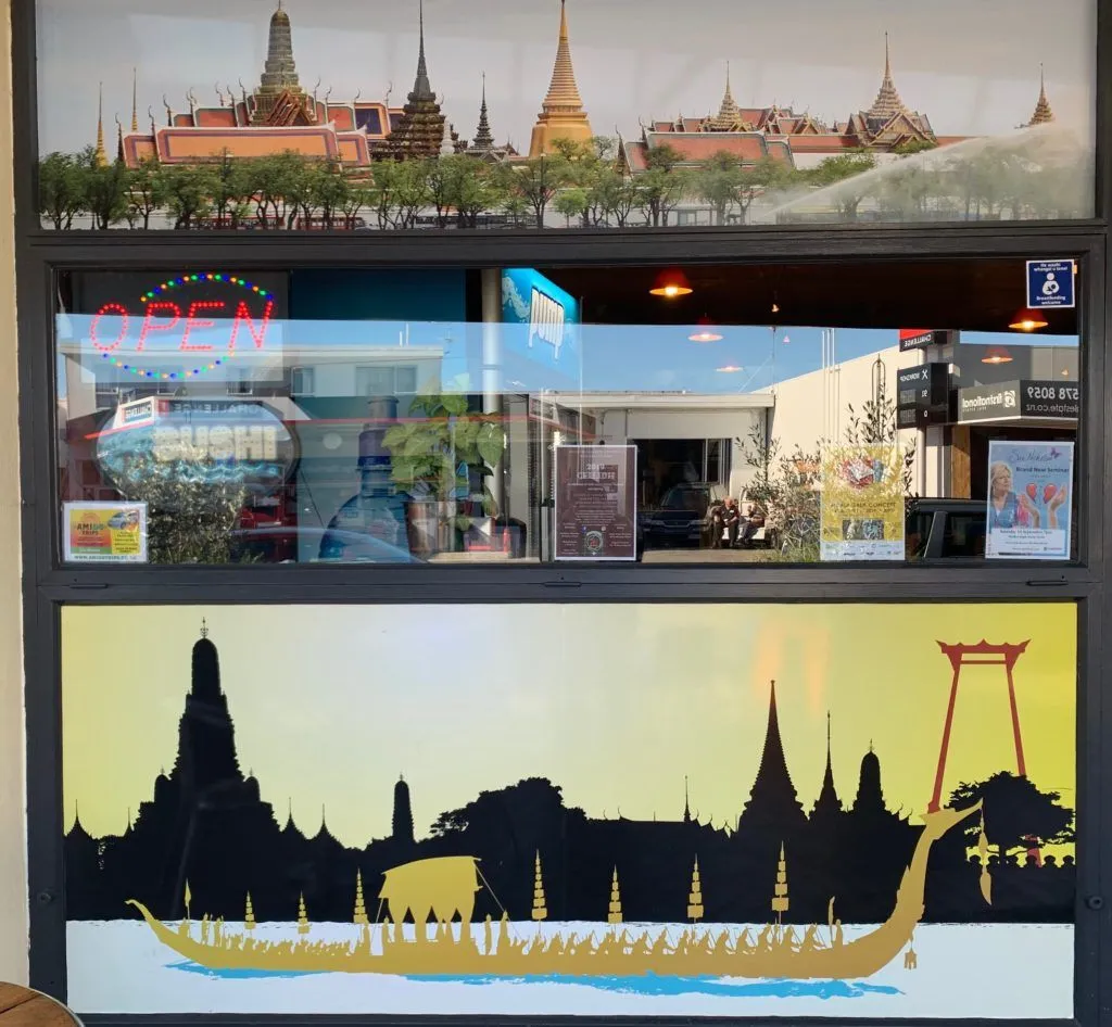 The Chai-Yo Café storefront window decorated with Thai artwork and an OPEN sign