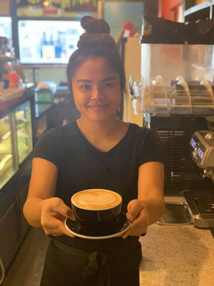 Hands holding a warm cup of coffee at Chai-Yo Café