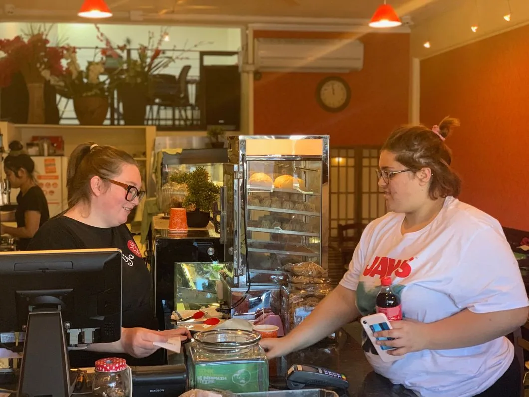 Two Chai-Yo team members serving behind the café counter
