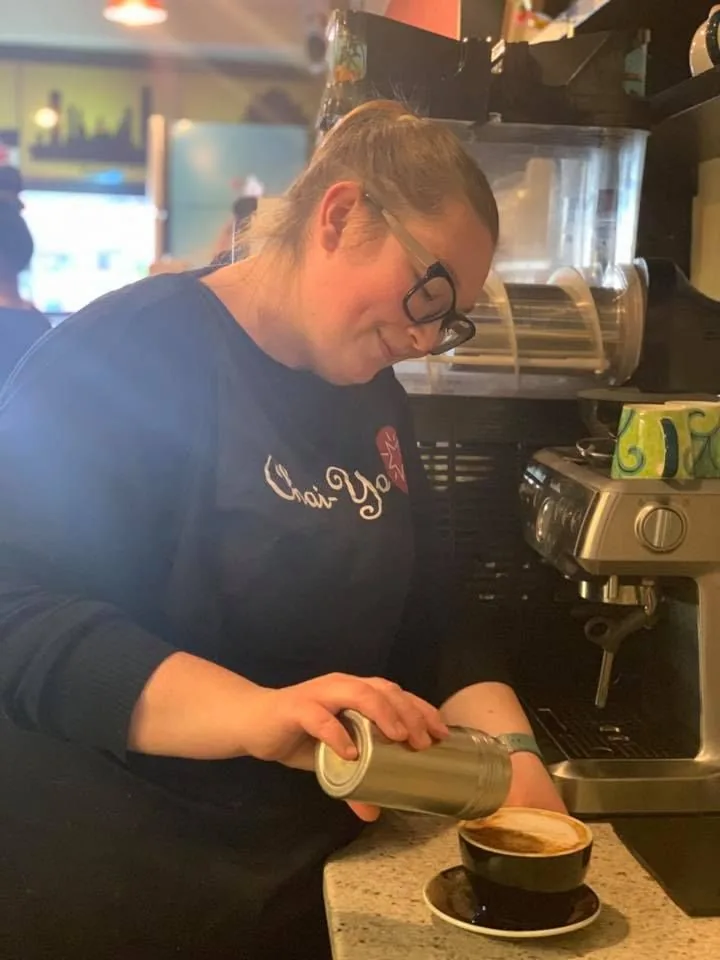 Milk being poured into a cup of coffee at Chai-Yo Café